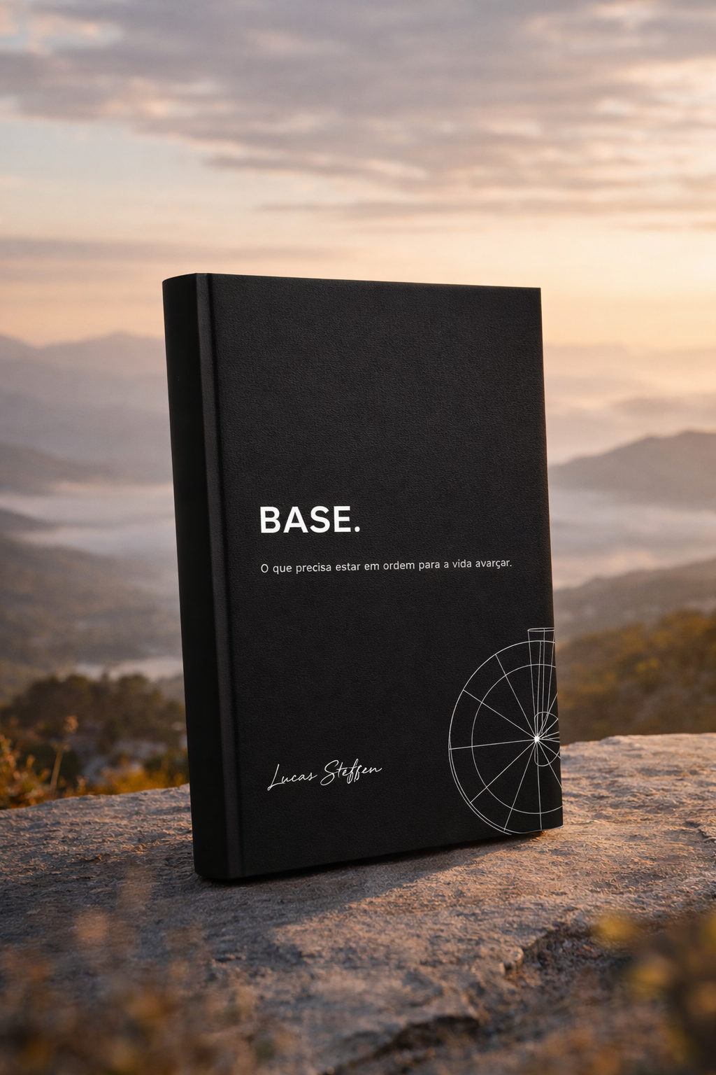 Livro BASE apoiado sobre uma rocha com paisagem ao fundo